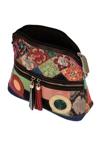 Flerfarvet patchwork-taske lavet af tekstureret læder med blomsterprint, to lynlåslommer og dekorative kvaster.