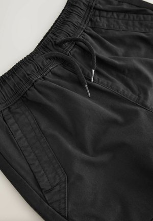 Schwarze Shorts mit elastischem Bund und Kordelzug. Verfügt über Seitentaschen und glattes Material mit leichtem Glanz.