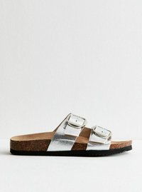 Sandalias de slide metálicas plateadas con dos correas ajustables y hebillas, planta de corcho, suela de goma texturizada, diseño plano para uso casual.