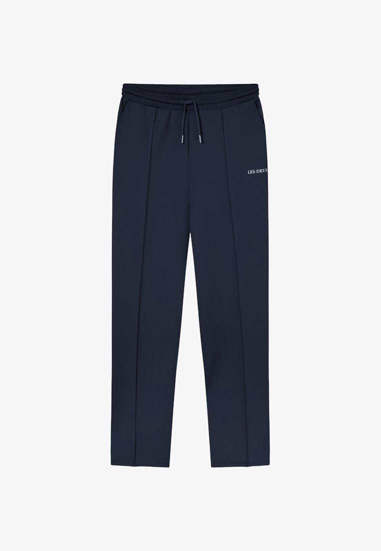Pantalon de survêtement marine avec une taille élastique, cordon de serrage et coutures latérales. Présente "LES DEUX" en texte blanc sur la jambe gauche. Texture de tissu lisse.