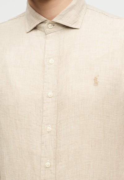 Μπεζ καρό πουκάμισο με κουμπιά, μυτερό γιακά και μικρό κεντημένο λογότυπο παίκτη πόλο στο αριστερό στήθος.