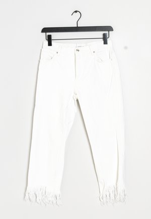 Białe dżinsy o luźnym kroju, z postrzępionym dołem, pięcioma kieszeniami oraz zapięciem na zamek błyskawiczny i guzik.