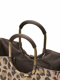 Tote Bag aus beigem Stoff mit braunem Leopardenmuster, großen goldfarbenen runden Griffen und einer Reißverschlusstasche im Innenraum.