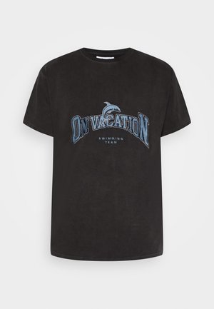 Czarna koszulka z krótkim rękawem z niebieskim napisem "NA WAKACJACH" oraz grafiką delfina nad mniejszym napisem "DRUŻYNA PŁYWACKA" z przodu.