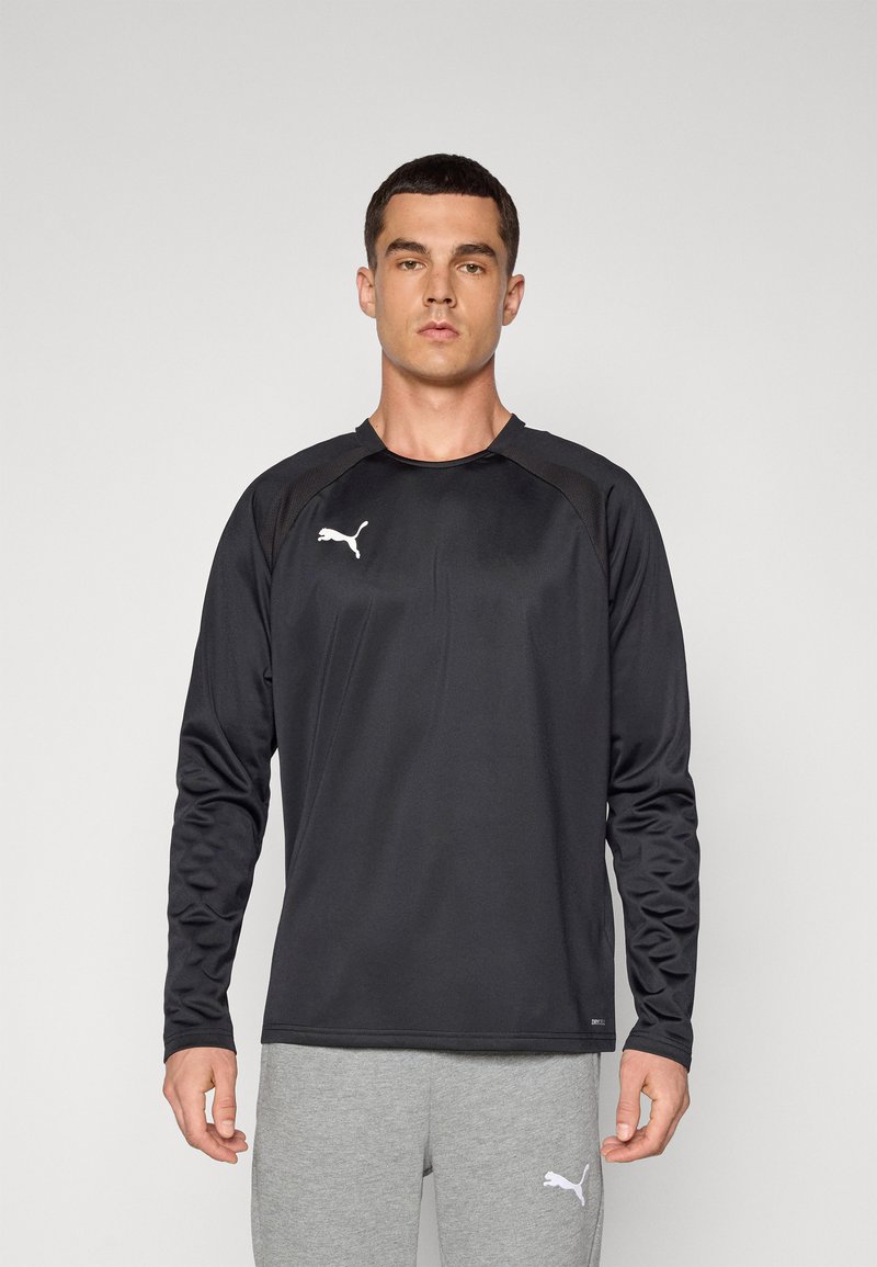 Svart langermet treningstrøye med rund hals, laget av glat stoff. Har en hvit Puma-logo på brystet og teksturerte skulderpaneler.