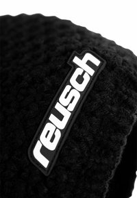 Black textured fabric hand warmer featuring a prominent white "reusch" logo in a rectangular black patch.