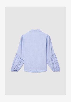 Blouse bleu clair à manches longues avec manches bouffantes froncées, poignets élastiques et col haut, vue de dos sur un fond uni.