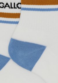 Calze bianche con strisce marroni e azzurri chiaro, dotate di punta e tallone rinforzati. Nome del brand "Gallo" stampato in nero.