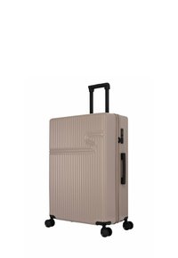 Harde koffer in een beige tint, met verticale ribbelstructuur, zwarte trolleyhandvat en vier wielen voor mobiliteit.