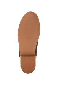 Suela de zapato marrón con agarre texturizado y tacón cuadrado bajo, vista desde la parte inferior.