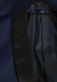 Blazer blu navy con rever in satin nero e fodera interna liscia, caratterizzato da un design elegante e una vestibilità su misura.