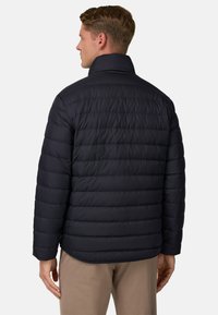 Granatowa kurtka puchowa z poziomym wzorem pikowania, wysokim kołnierzem i długimi rękawami. Wykonana z gładkiego, lekkiego materiału.