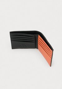 Portafoglio in pelle bifold nero e arancione aperto, che mostra multiple fessure per carte su entrambi i lati su uno sfondo bianco.