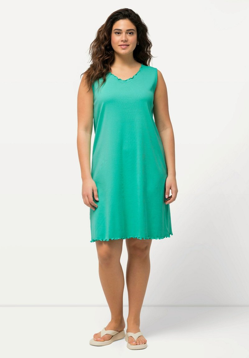 Un vestido sin mangas, a la altura de la rodilla, en un brillante color verde, hecho de una tela suave, con un escote y un dobladillo con forma de ondas, y un corte holgado.