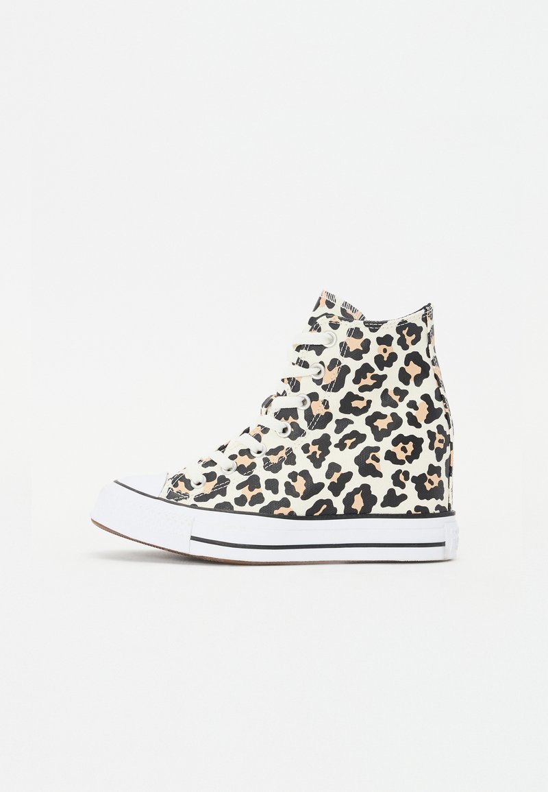 Høyhælte joggesko med leopardmønster, som har overdeler i stoff, hvit gummitåhette, svart kant og snøring.