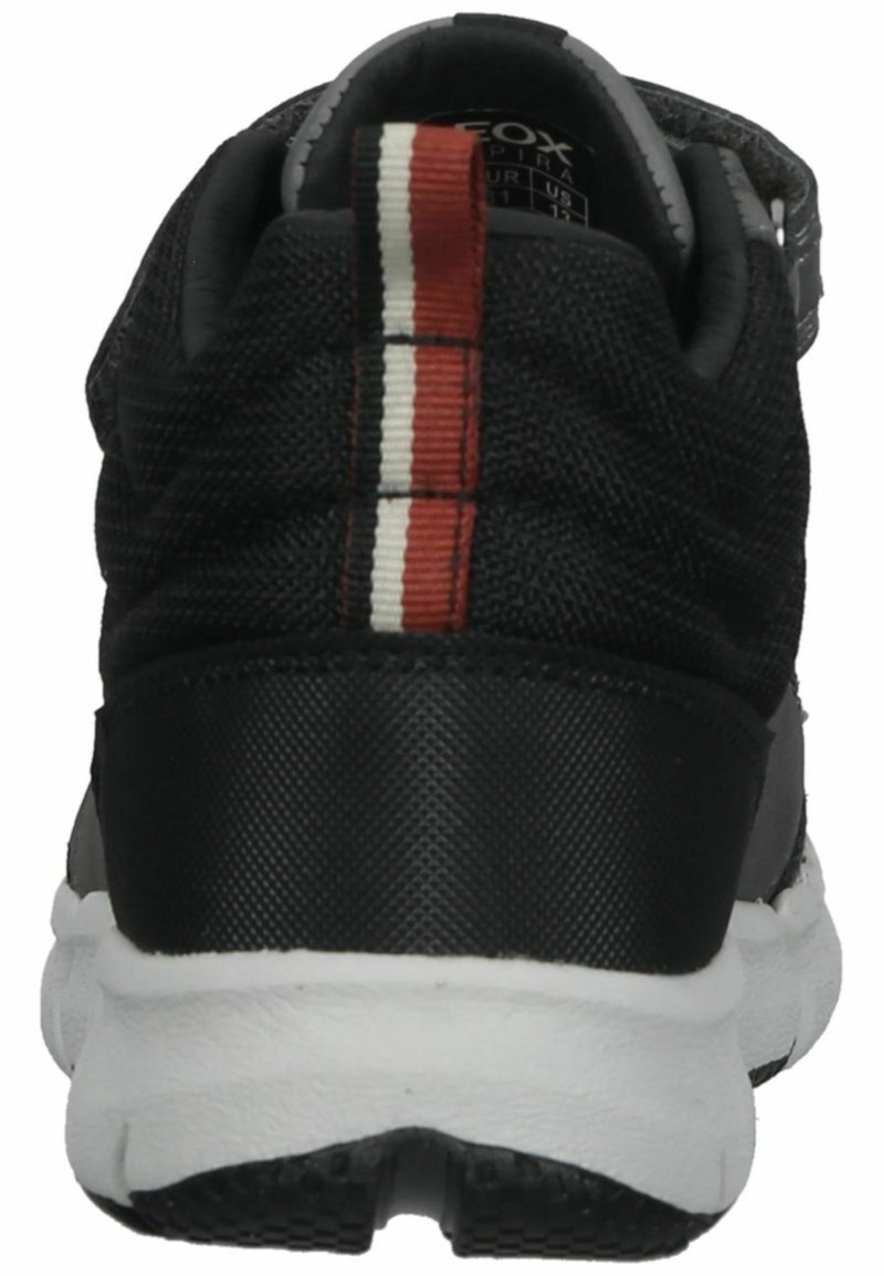 Czarny tekstylny sneaker z wyściełanym obcasem, białą podeszwą środkową i dekoracyjnym paskiem w czerwono-białe pasy z tyłu.