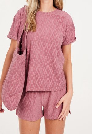 Różowy, teksturowany zestaw do domu, składający się z krótkiego topu z krótkim rękawem i dopasowanych szortów, oba z geometrycznym wzorem. W zestawie znajduje się także pasująca torba.