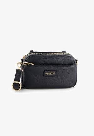 Black pebbled leather crossbody bag with gold hardware, dual zip compartments, adjustable strap, and embossed brand name on front.