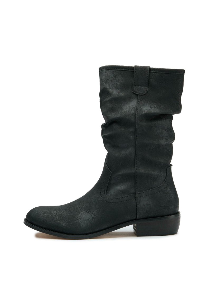 Black ankle boot made of textured faux leather, featuring a slouchy design, rounded toe, low stacked heel, and side seams.