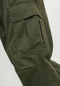 Pantalones cargo en verde oliva con un bolsillo lateral, hechos de una tela duradera, con costuras visibles y un ajuste estructurado.