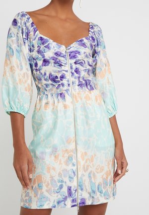 Jurk met korte mouwen met paarse en blauwe abstracte patronen op een witte en lichtmintgroene achtergrond; beschikt over een ritssluiting aan de voorkant en een geplooide taille.