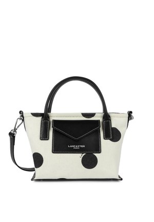 Biała torebka z dużymi czarnymi grochami, czarne skórzane uchwyty, przednia kieszeń oraz odpinany pasek na ramię, markowa Lancaster Paris.