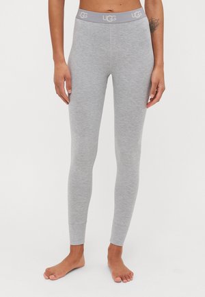Světle šedé legíny vyrobené z měkkého elastického materiálu. Mají široký elastický pas s logem "UGG". Úzký střih a bezšvový design.