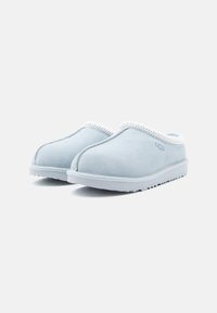 Gaiši zila zamšāja čības ar teksturētu gumijas zoli un baltu dekoratīvu malu. Iezīmējas ar noapaļotu pirkstu un bezšuvju augšdažas dizainu.