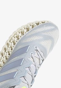 Scarpa da ginnastica grigia chiara con tomaia in mesh testurizzato, caratterizzata da accenti blu e una suola distintiva stampata in 3D di colore bianco.