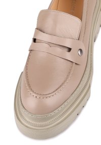 Beige Leder-slipper mit runder Spitze, dekorativem Riemen und silberfarbigen Beschlägen, auf einer strukturierten cremefarbenen Plattformsohle.
