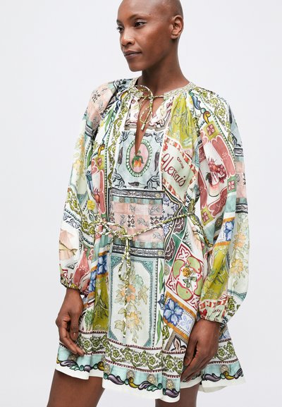 Rochie scurtă dintr-un țesătură ușoară, cu un amestec de modele florale și geometrice în culori pastelate, având decolteu cu șnur și mâneci bufante.