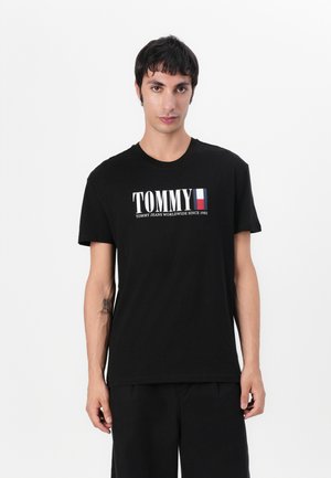 Schwarzes Baumwoll-T-Shirt mit "TOMMY"-Logo in Weiß und Rot, Rundhals, kurze Ärmel, glatte Textur und entspannte Passform.
