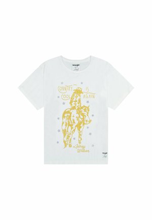 Camiseta de algodón blanca con un gráfico amarillo de un vaquero montando un caballo y el texto "EL PAÍS ESTÁ DE MODA DE NUEVO" y estrellas, diseñado por Lainey Wilson.