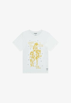 Camiseta de algodón blanca con un gráfico amarillo de un vaquero montando un caballo y el texto "EL PAÍS ESTÁ DE MODA DE NUEVO" y estrellas, diseñado por Lainey Wilson.