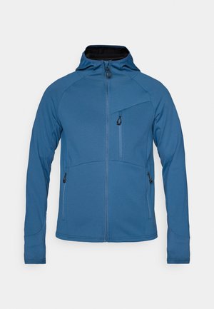 Veste légère bleue avec capuche rembourrée, poches zippées, tissu texturé et fermeture éclair sur le devant. Présente un design ajusté.