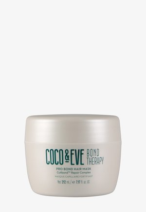 Hvid cirkulær beholder med glat finish, turkis tekst. Etiketten angiver "Coco & Eve Bond Therapy Pro Bond Hair Mask," 212 ml.