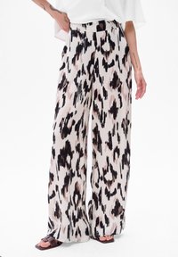 Pantalons taille haute à jambes larges en tissu crème avec un imprimé léopard abstrait noir et rose. Texture lisse avec une coupe décontractée.