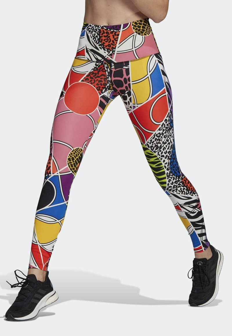 Leggings colorés présentant un mélange de motifs géométriques et animaliers dans des teintes de rouge, bleu, jaune et noir. Fabriqués en matière extensible.