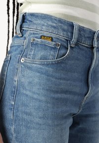 Τζιν παντελόνι σε ανοιχτό μπλε χρώμα με ξεθωριασμένο φινίρισμα. Διαθέτει κίτρινη ετικέτα G-Star, κλασικό σχέδιο πέντε τσεπών και μεταλλικές λεπτομέρειες.