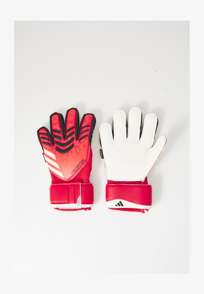 Gants de gardien Adidas avec un design texturé rouge et noir d'un côté et paume blanche. Dispose d'une sangle ajustable rouge au poignet.