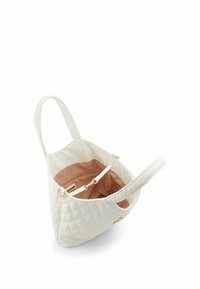 Sac fourre-tout matelassé blanc avec une seule poignée, doté d'un intérieur beige clair, d'une poche intérieure et d'accents en métal doré.