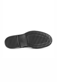 Suola di scarpa in gomma nera con scanalature e rigonfiamenti testurizzati per una migliore aderenza. Presenta un'area della punta liscia e un marchio inciso.