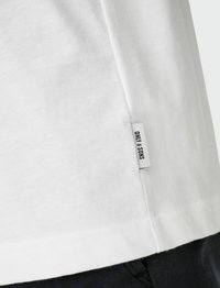 Witte katoenen T-shirt met een rechte snit, voorzien van een klein label aan de onderrand met de tekst "ONLY & SONS". Glad textuur, minimalistisch design.