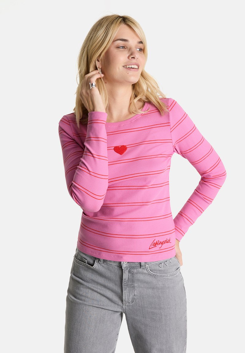 Rosa Langarmshirt mit roten Streifen und einem kleinen gestickten roten Herzen. Mit einem gerippten Stoff und einem Logo am Saum.