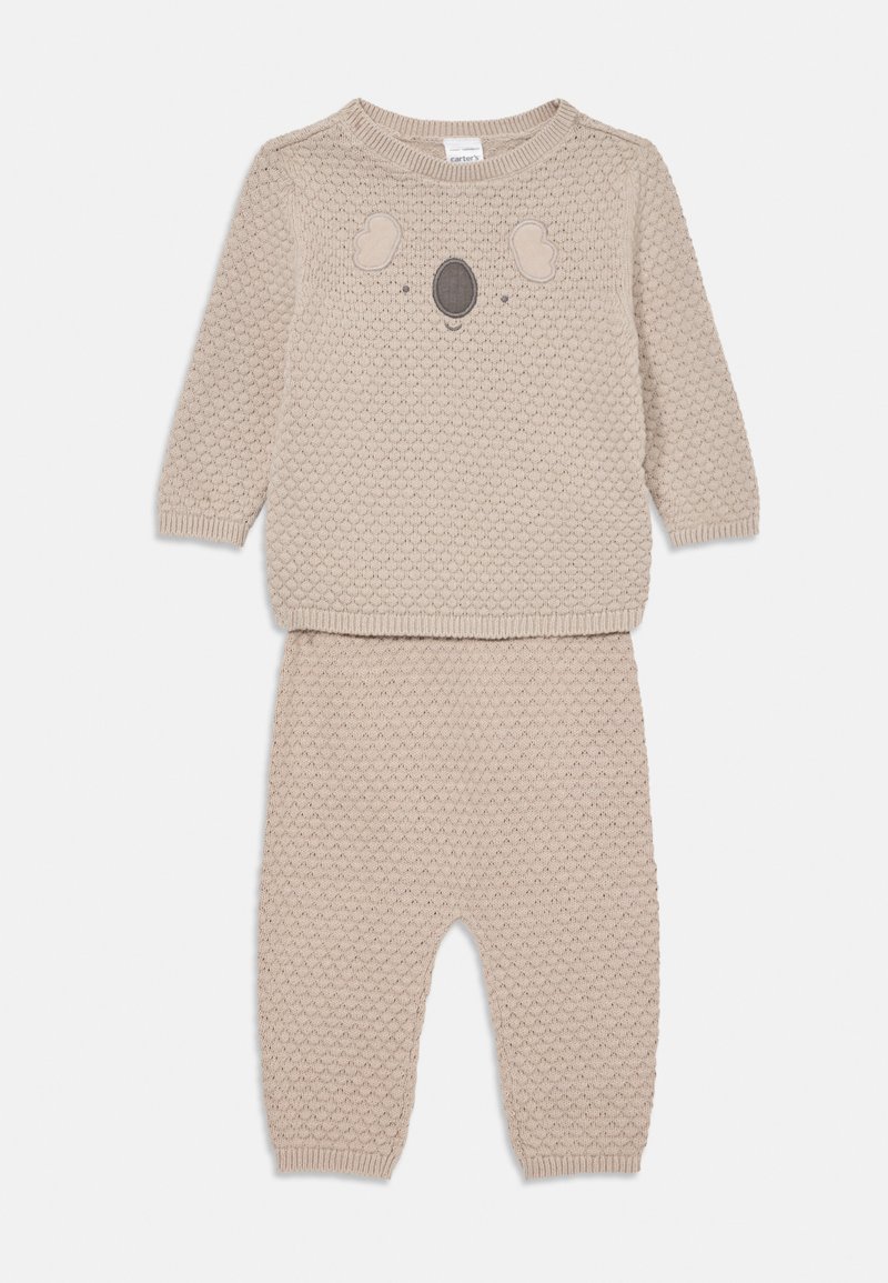 Bežani pleteni dječji set s dva dijela koji uključuje majicu dugih rukava s dizajnom lica koale i odgovarajuće hlače sa teksturom.