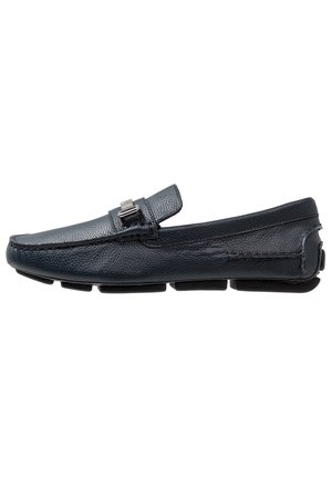Black leather loafer with textured finish, metal buckle detail on the top, and segmented rubber sole for grip and comfort.