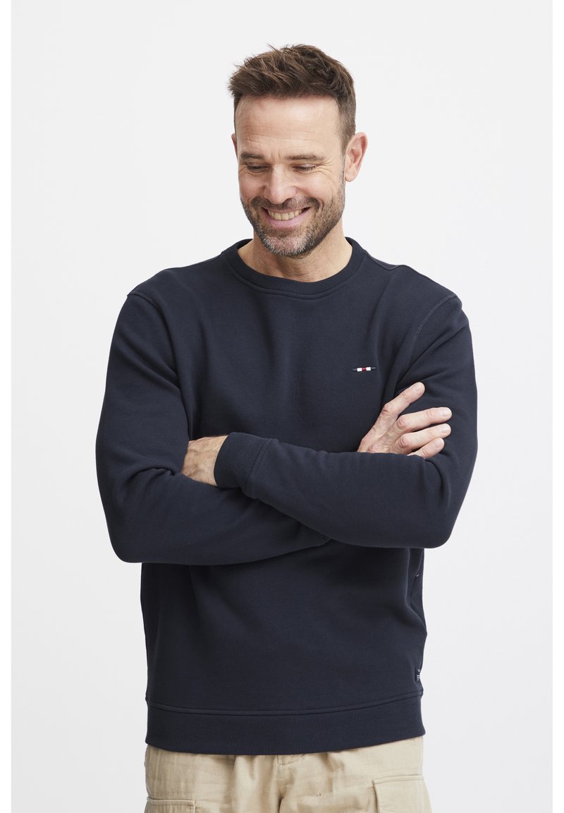 Felpa blu navy in misto cotone, design a girocollo, con polsini e orlo a coste, caratterizzata da un piccolo logo multicolore sul petto.