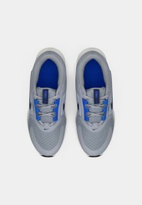 Grå sportskor med blå accenter, mesh-material, rund gummitå och traditionella snörningar. Har en vadderad tunga och innersula.