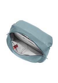 Pochette da viaggio in tessuto blu morbido con chiusura a zip, dotata di un interno grigio e di una tasca interna con un dettaglio etichetta rossa.