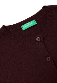 Maronfarbener Strickcardigan mit Rundhalsausschnitt, gerippten Bündchen und zwei braunen Knöpfen. Das Etikett trägt die Aufschrift „United Colors of Benetton.“